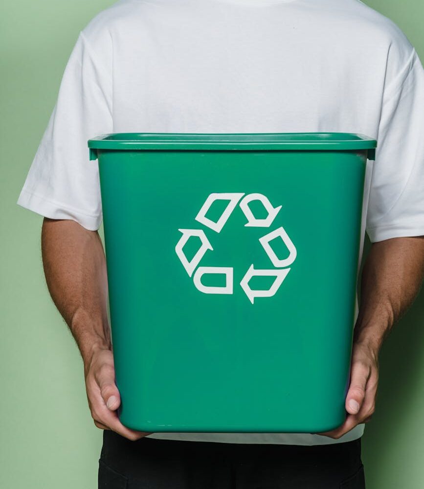 man in white t shirt holding green box